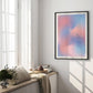 Black-framed pink and blue gradient art print reading “The only way out is through” hanging in a sunlit bedroom.