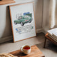 Oak-framed 1961 Jaguar E-Type art print beside a window, with a cup of tea in the foreground.