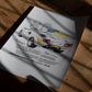 Unframed 1985 Lamborghini Countach art print lying in patterned sunlight on a wooden table.