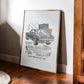 Oak-framed 1969 Chevrolet Camaro collage artwork leaning against a sunlit wall beside a wooden cabinet.