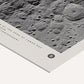 Close-up of an unframed Artemis II art print showing a black-and-white cratered lunar surface and printed mission details.