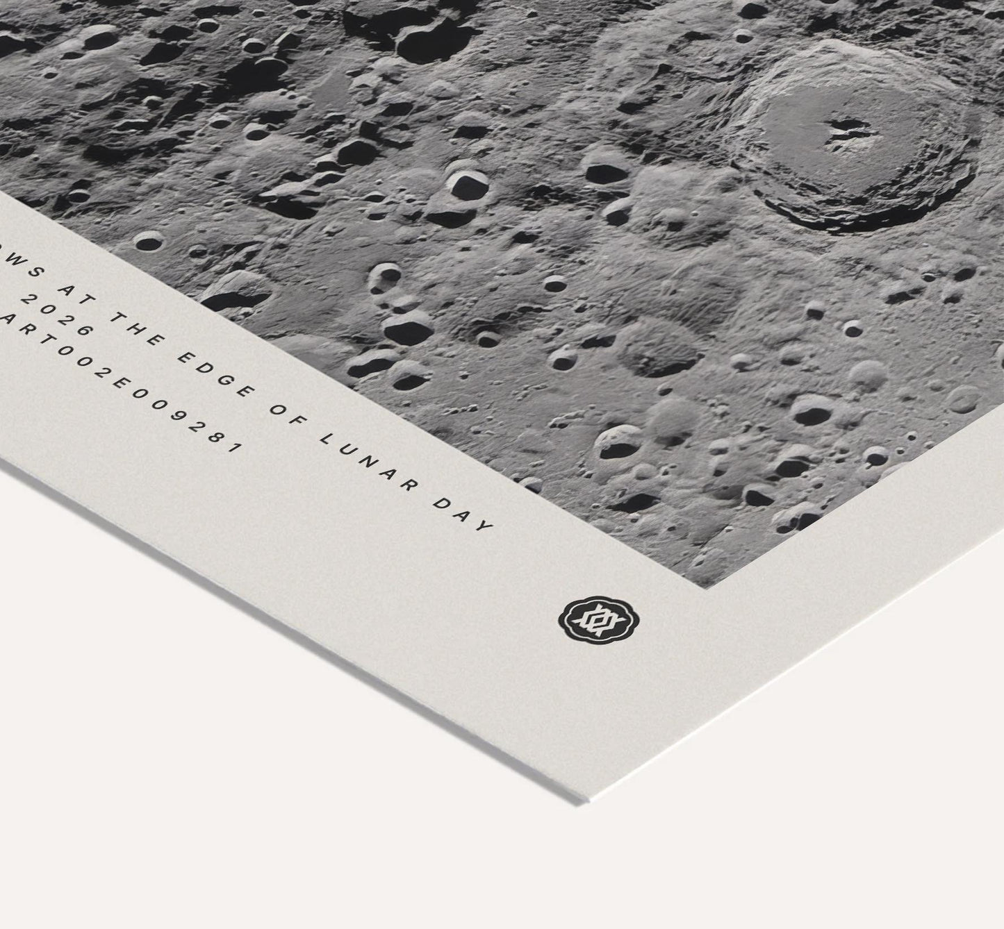 Close-up of an unframed Artemis II art print showing a black-and-white cratered lunar surface and printed mission details.