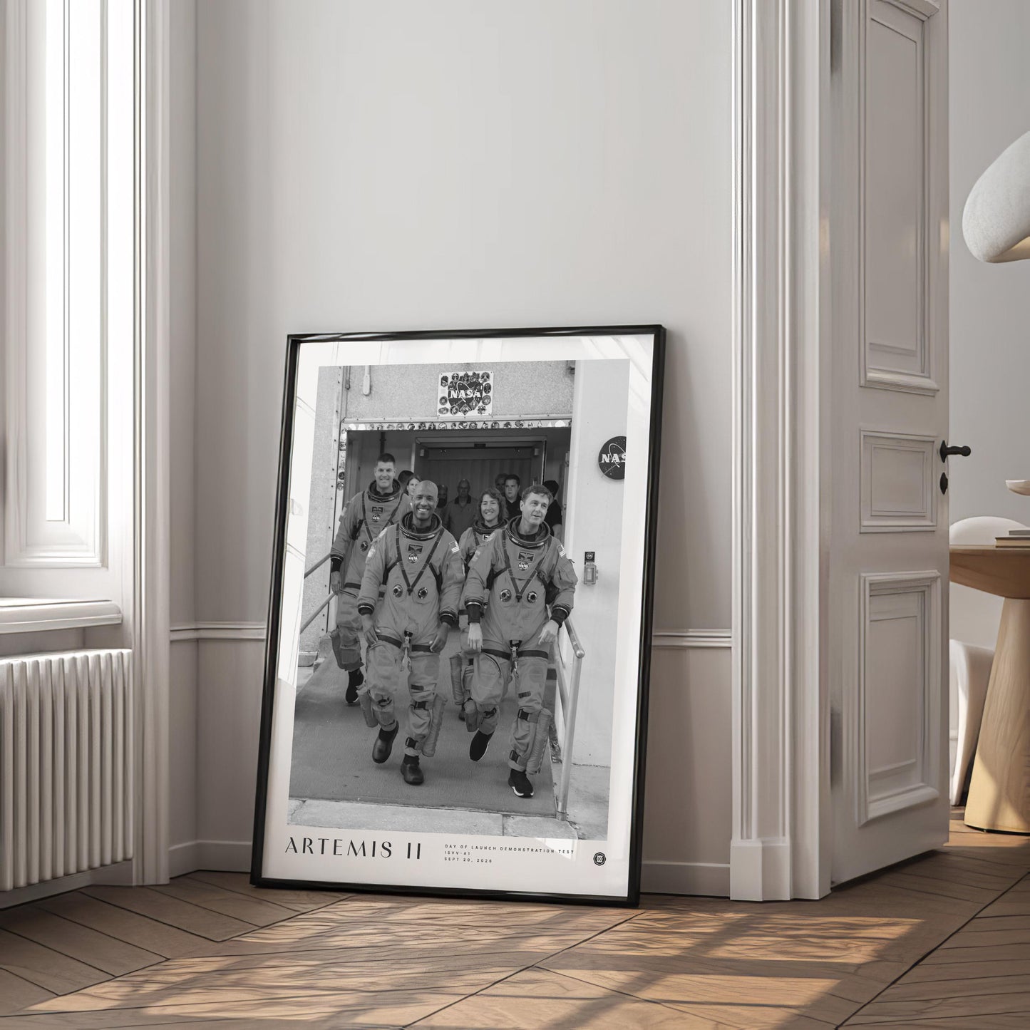 Framed Artemis II crew artwork displayed in an interior setting.