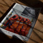 Unframed Artemis II crew-suit art print lying on a sunlit wooden table.