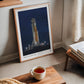 Light wood-framed Artemis II rocket art print leaning near a window and a table with a cup of tea.