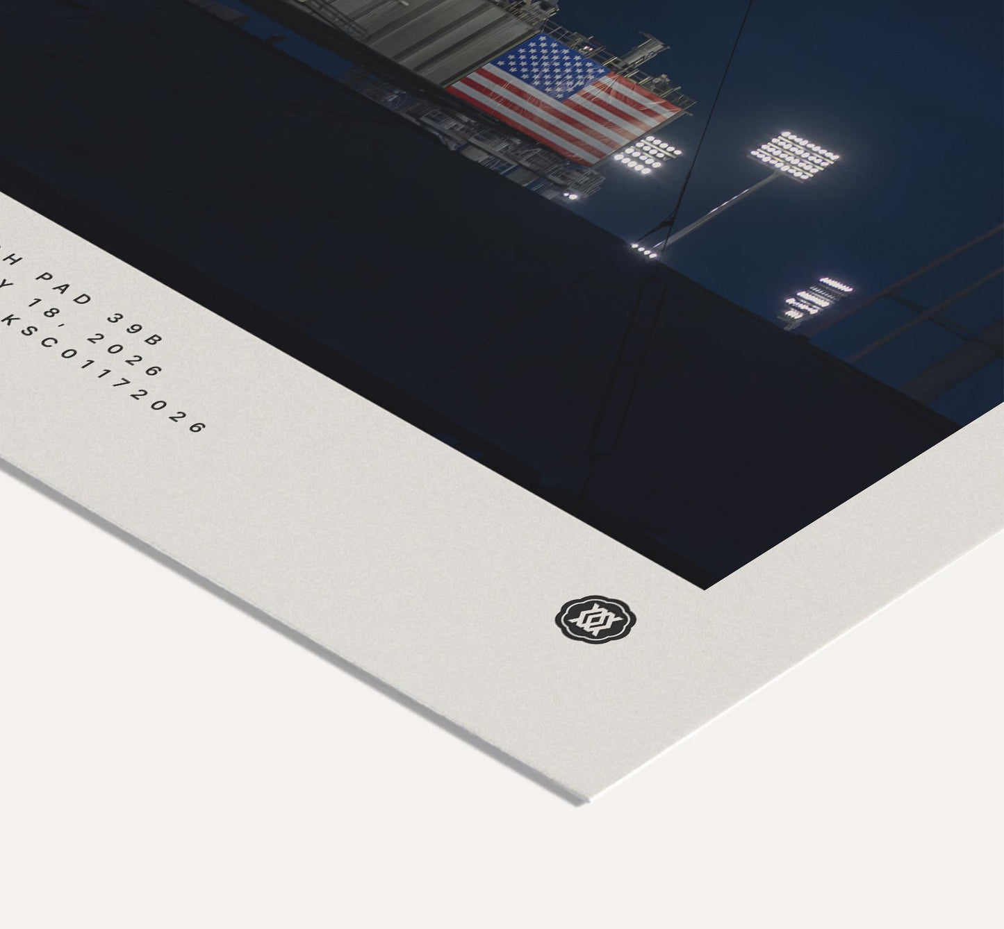 Close-up of an Artemis II art print corner showing an American flag, launch-pad lights, printed details, and a small emblem.