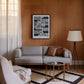 Black-framed due process artwork hanging above a gray sofa in a wood-paneled living room.