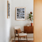 Two Oak-framed women's rights legal cases artworks displayed in a sitting area with an armchair and potted plant.