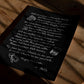 Unframed black dining-themed art print lying on a wooden floor in patterned sunlight.