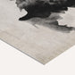 Close-up of textured paper with black and gray watercolor artwork.