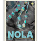White-framed NOLA 1857 Mardi Gras art print featuring iridescent bead strands and a fleur-de-lis over grayscale fabric.