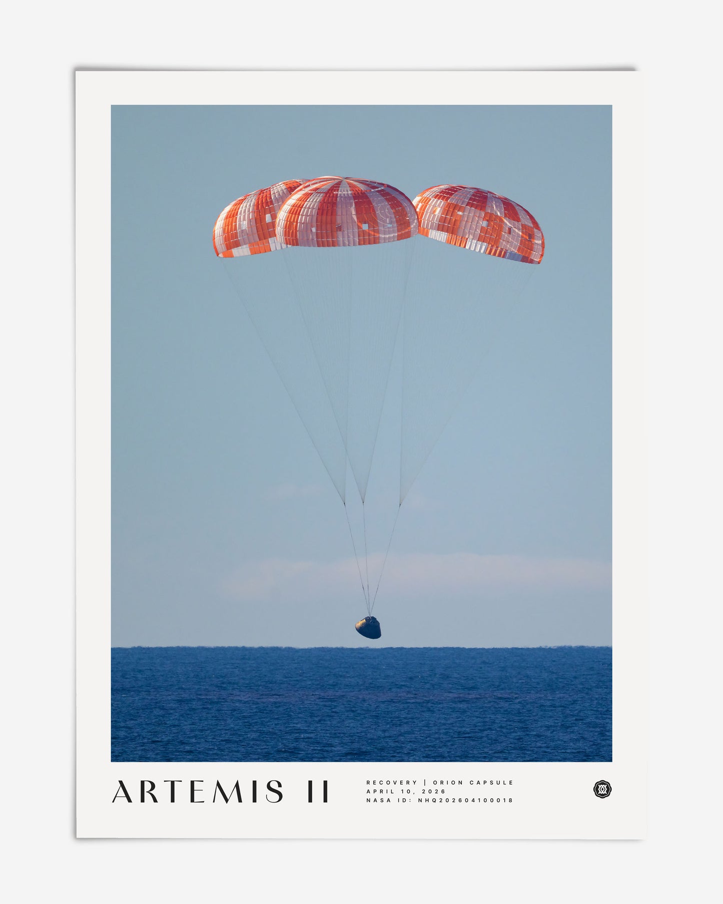 Unframed Artemis II art print showing the Orion capsule descending beneath three parachutes over the ocean.